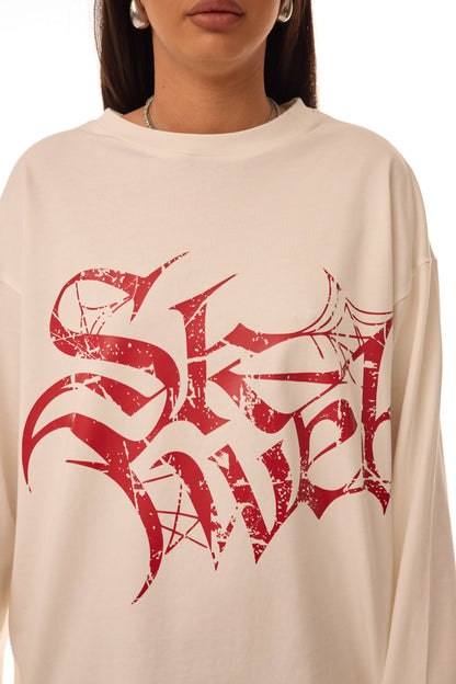 Close-up view of the Red Glyph White Long Sleeve Tee featuring distressed red gothic Skyweb logo on cream 300gsm cotton