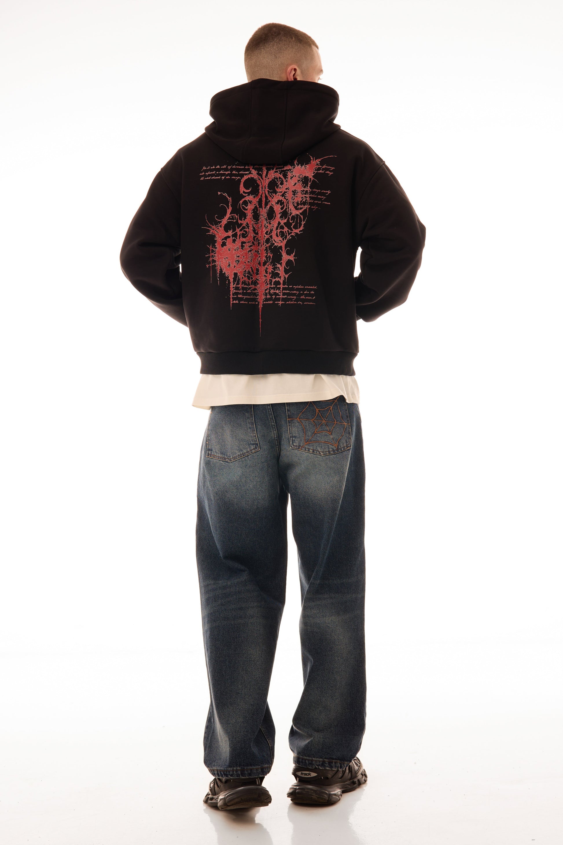 Model bărbat văzut din spate purtând Relic Black Hoodie, hanorac negru cu print grafic roșu pe spate, stil urban.