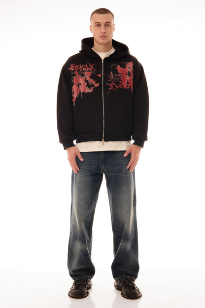 Model bărbat purtând Relic Black Hoodie, hanorac negru cu fermoar și print roșu pe față, stil streetwear oversized.