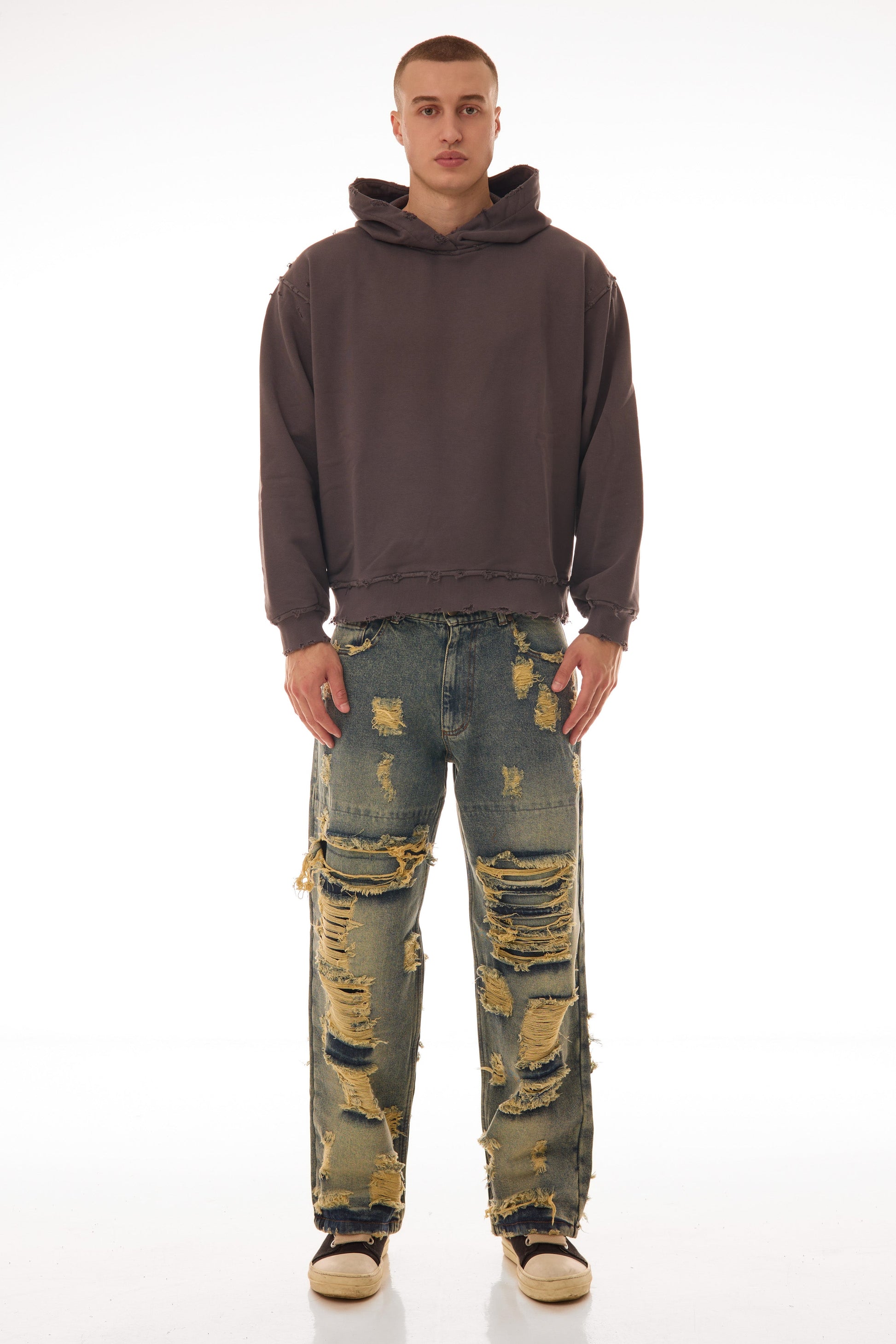 Model bărbat purtând Archived Grey Hoodie gri, fit oversized, bumbac 500 GSM, detalii raw & distressed, vedere față pe fundal alb