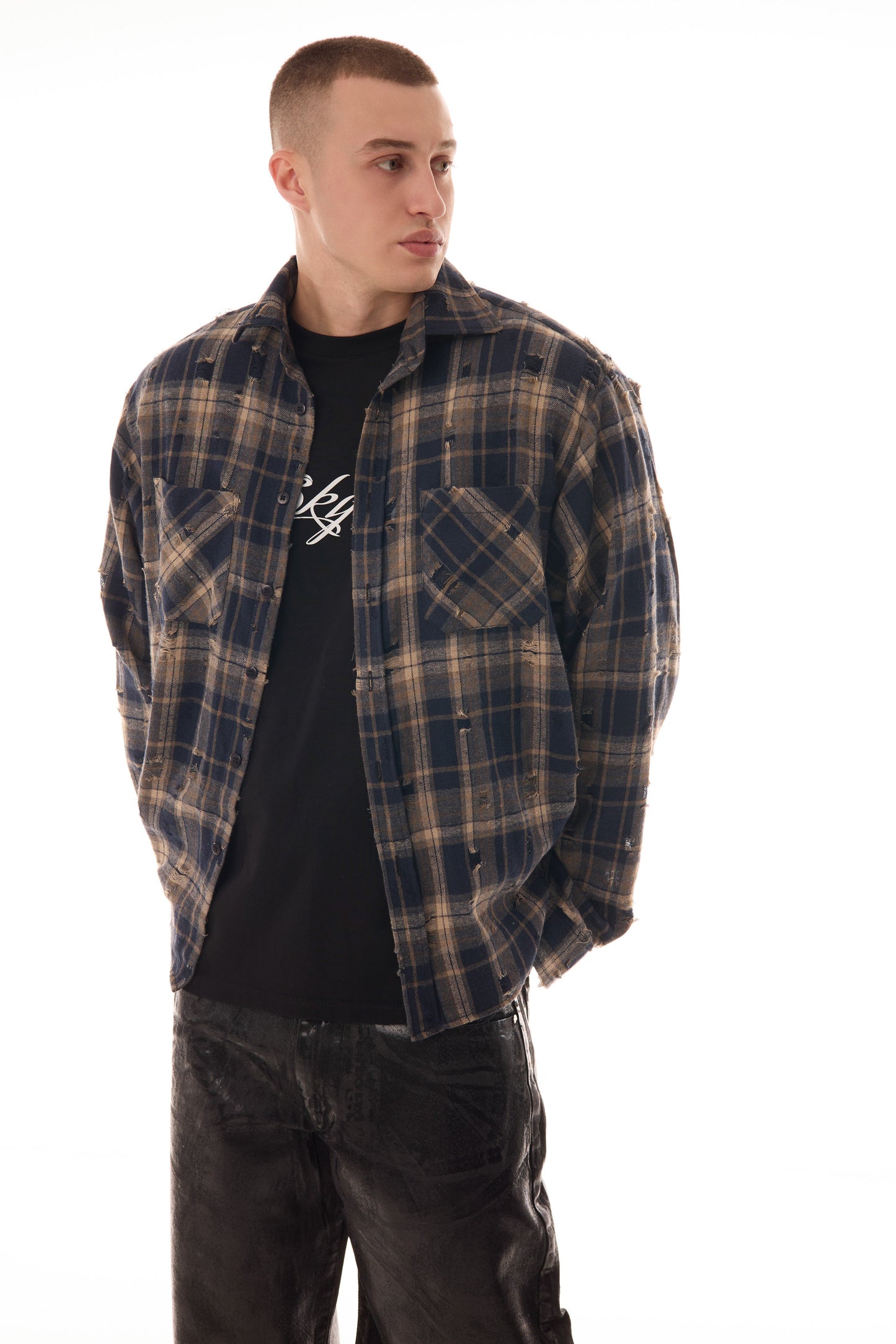 Model în poziție 3/4 purtând FRACTURE SHIRT, cămașă oversized ONE SIZE în carouri bej-negru, flannel 100% bumbac.