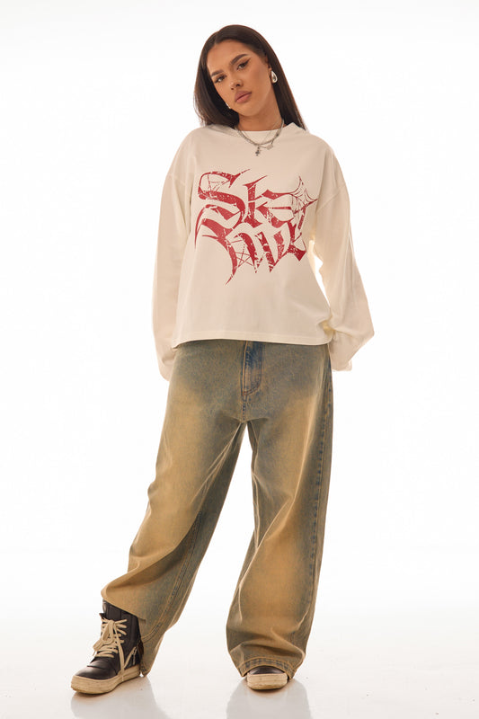 Model femeie purtând RED GLYPH WHITE LONG TEE crem, tricou oversized 300 GSM cu print roșu distressed, vedere frontală full body, outfit streetwear.