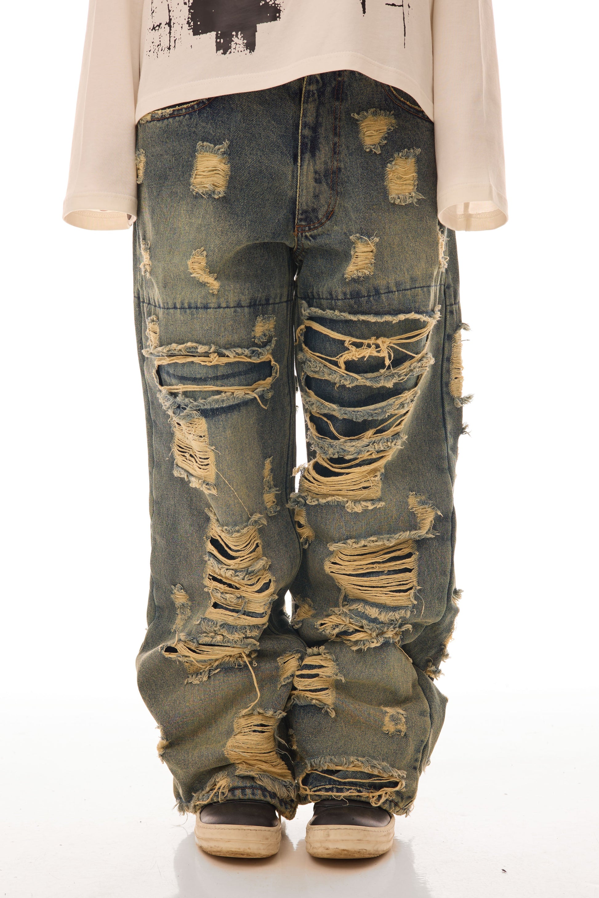 Close-up frontal cu model feminin purtând blugii Shattered Denim Blue 13.5 OZ, wide fit, cu distressed heavy și rupturi multiple.
