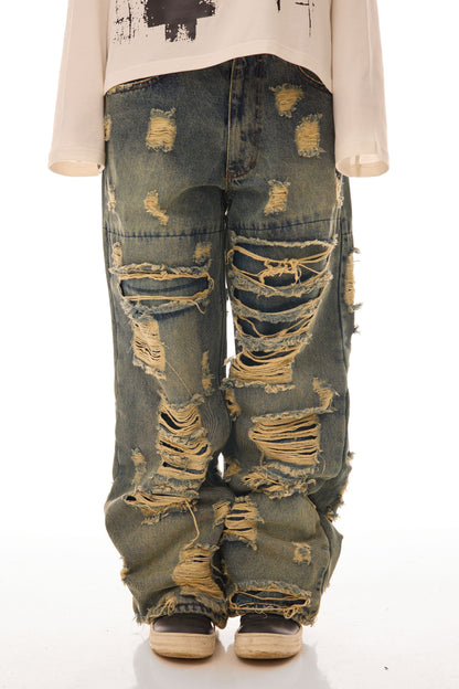 Close-up frontal cu model feminin purtând blugii Shattered Denim Blue 13.5 OZ, wide fit, cu distressed heavy și rupturi multiple.
